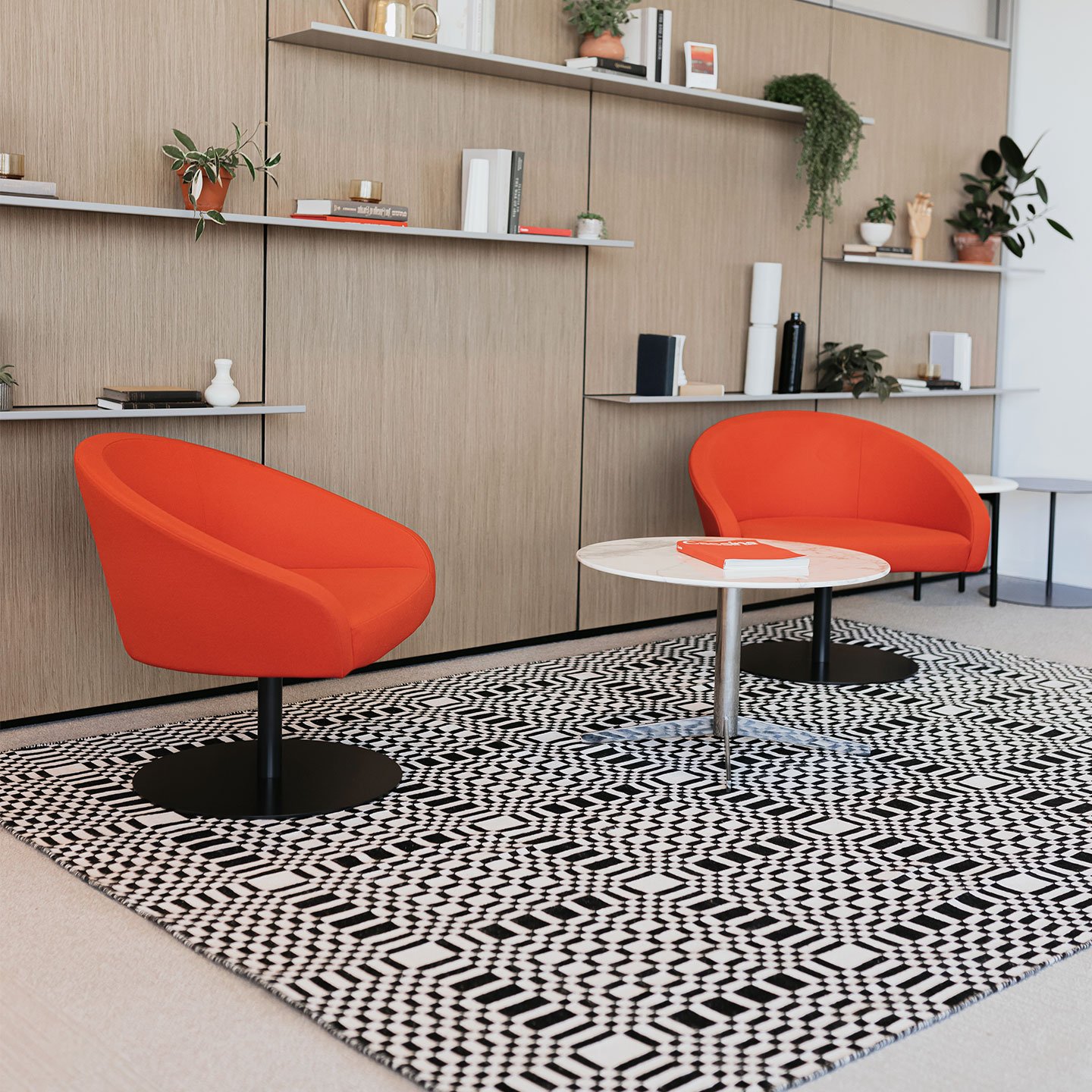 Haworth Patch Rug in black and white under orange chairs and white table in office space 