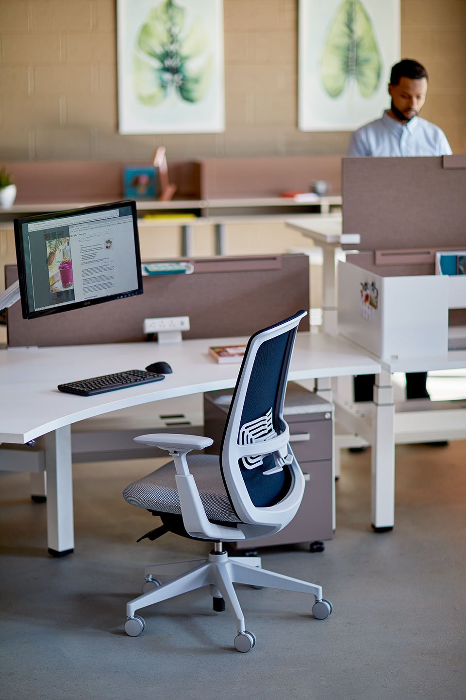 Haworth Belong Screen in brown on office desk with employee working