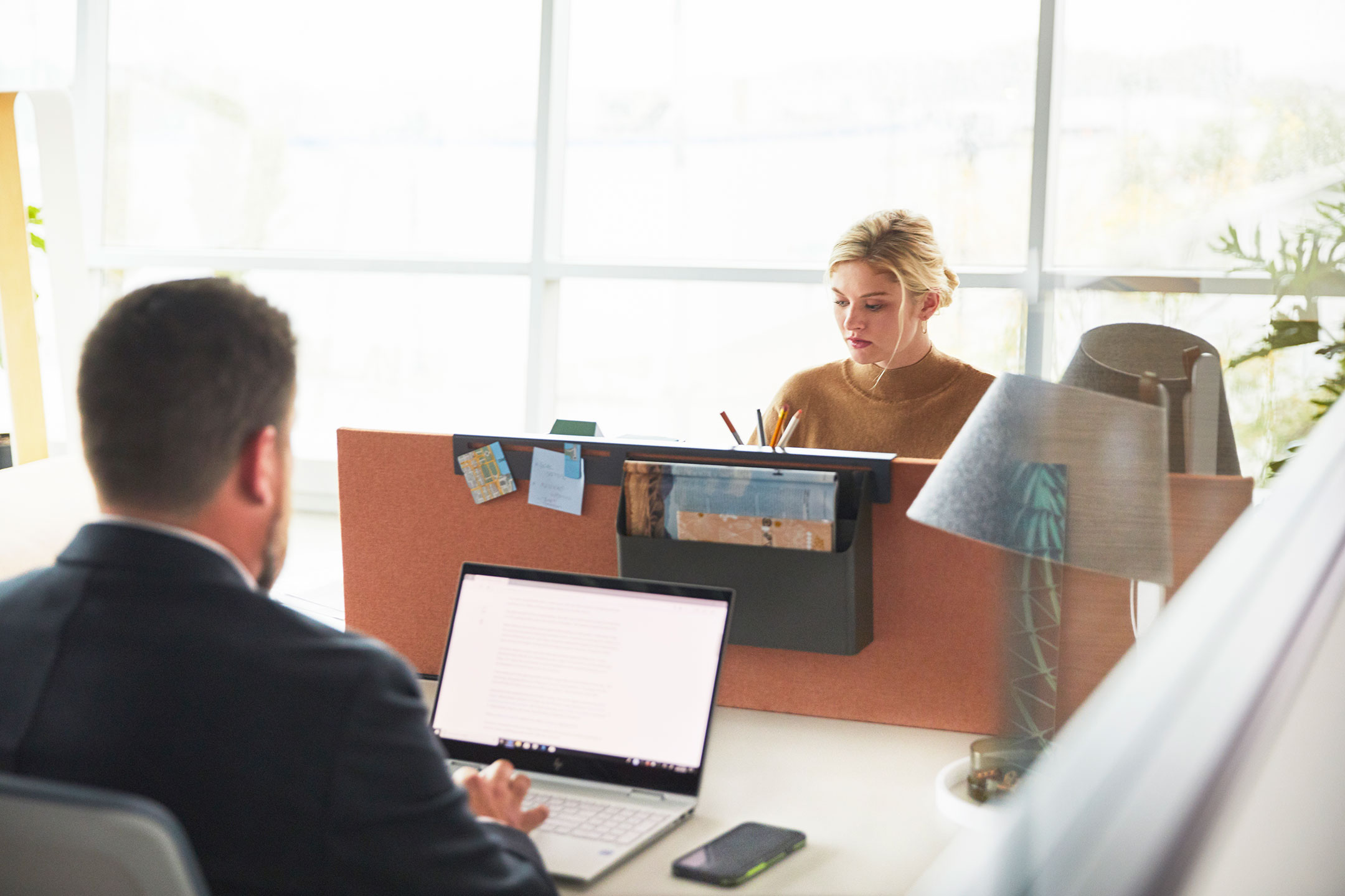 Haworth Belong Screen in red color dividing desks with employees working in office