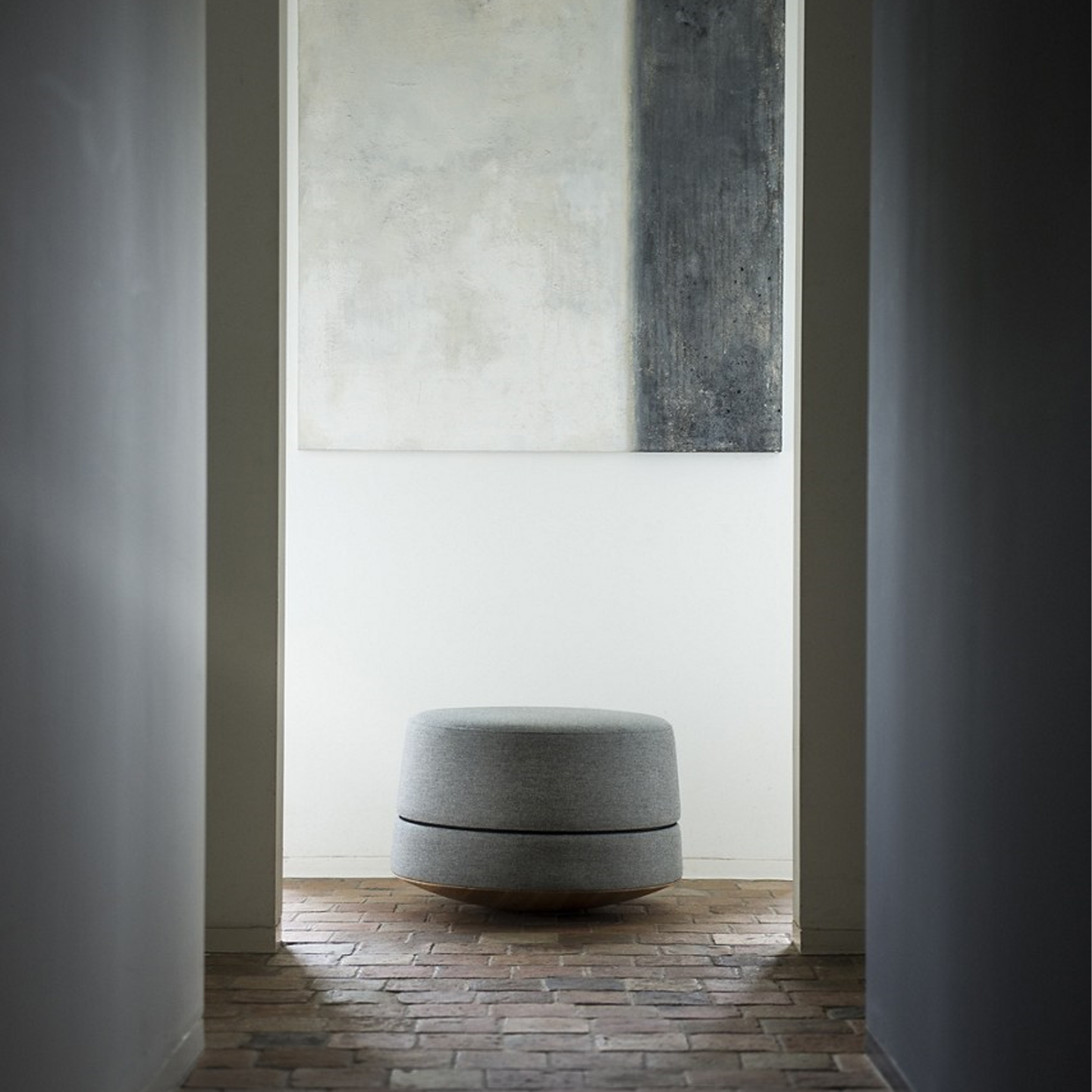 Haworth Buzzibalance pouf in grey color amidst grey pillars and a white wall