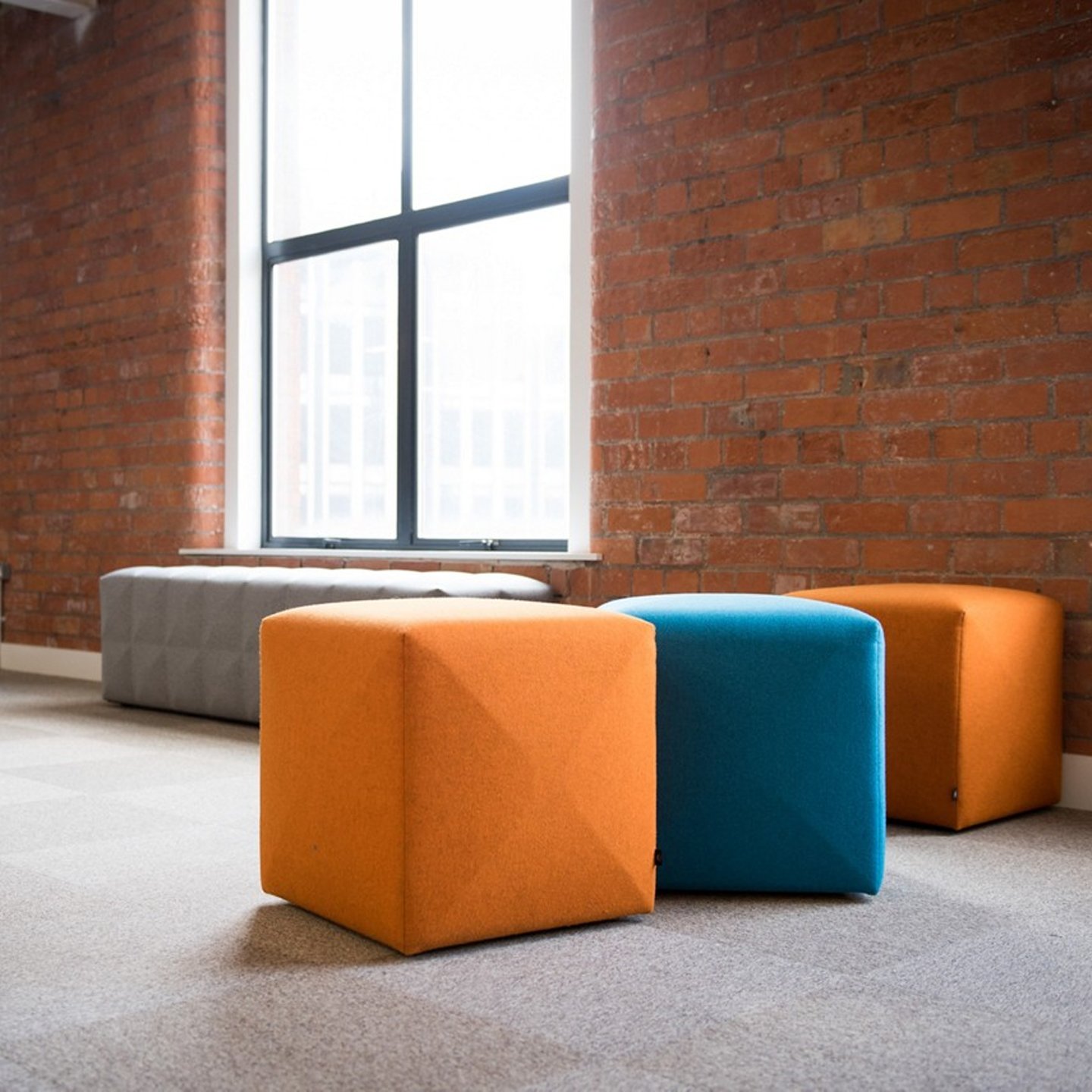 Haworth Buzzicube pouf in orange and blue in a open floorplan