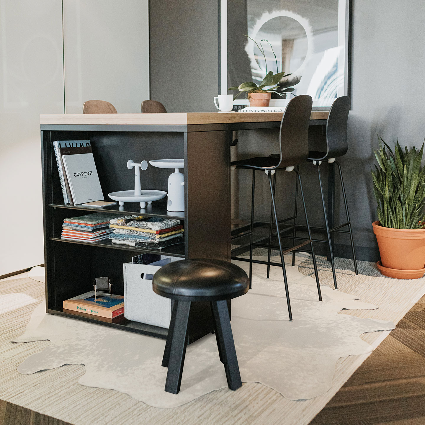Haworth BuzziMilk stool in black leather and wood in an open space