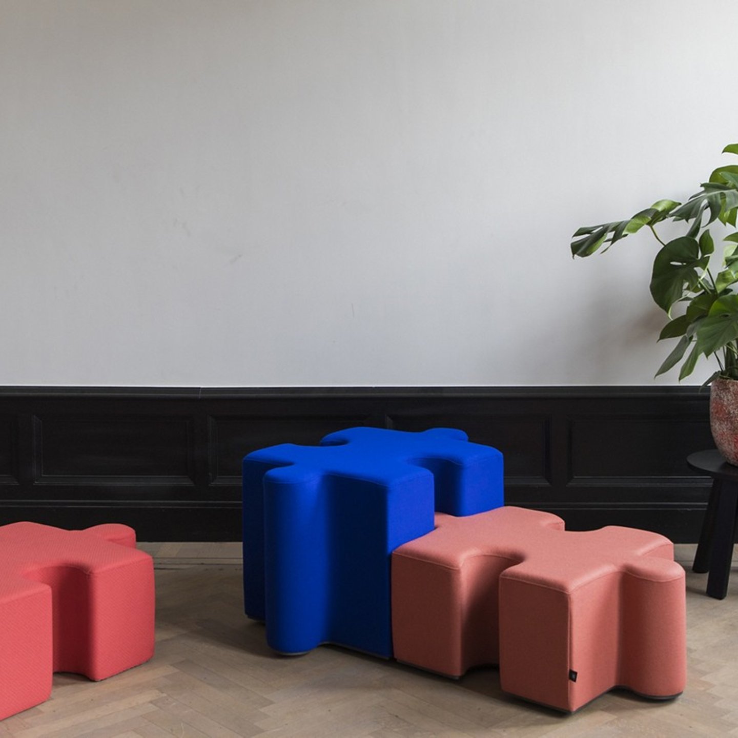 Haworth Buzzipuzzle poufs in red, pink and blue color in a jigsaw puzzle shape in a office lobby