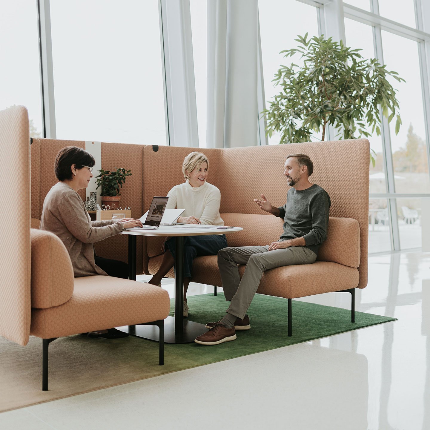 Haworth Cabana lounge connector screen in peach color being used by a group of coworkers in a open office space 