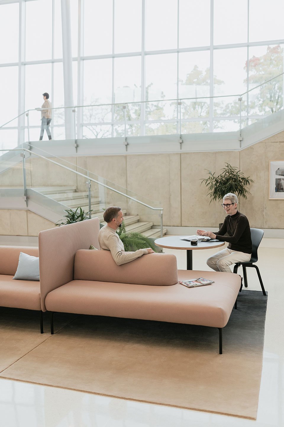 Haworth Cabana island lounge in brown leather being used by a couple of coworkers