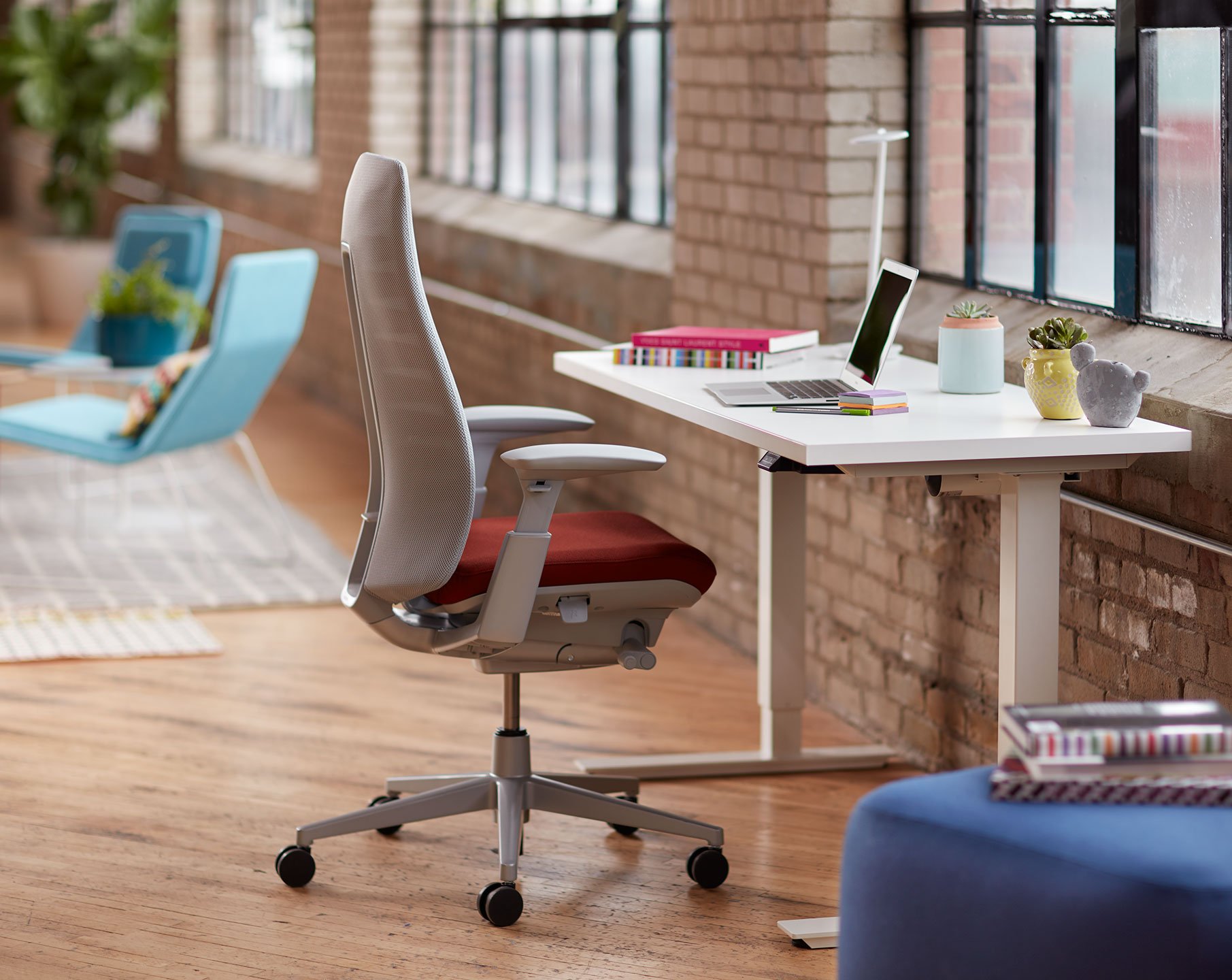 Haworth Fern task chair in grey and maroon upholstery at a casual workstation in a open floor space