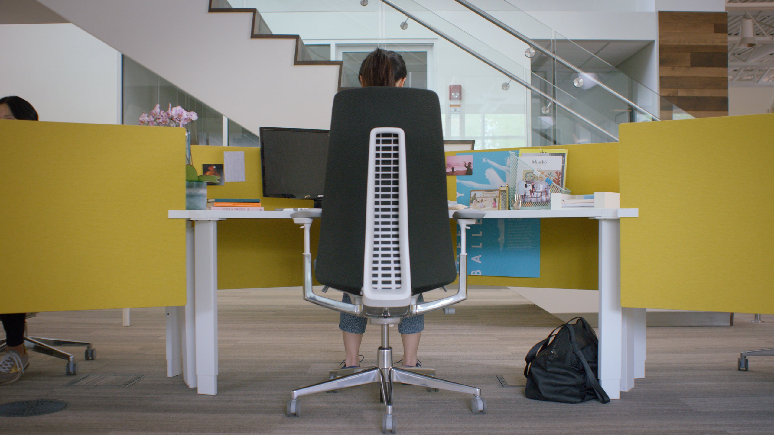 Haworth Fern Task chairs in black upholstery with workstations having a yellow divider screen