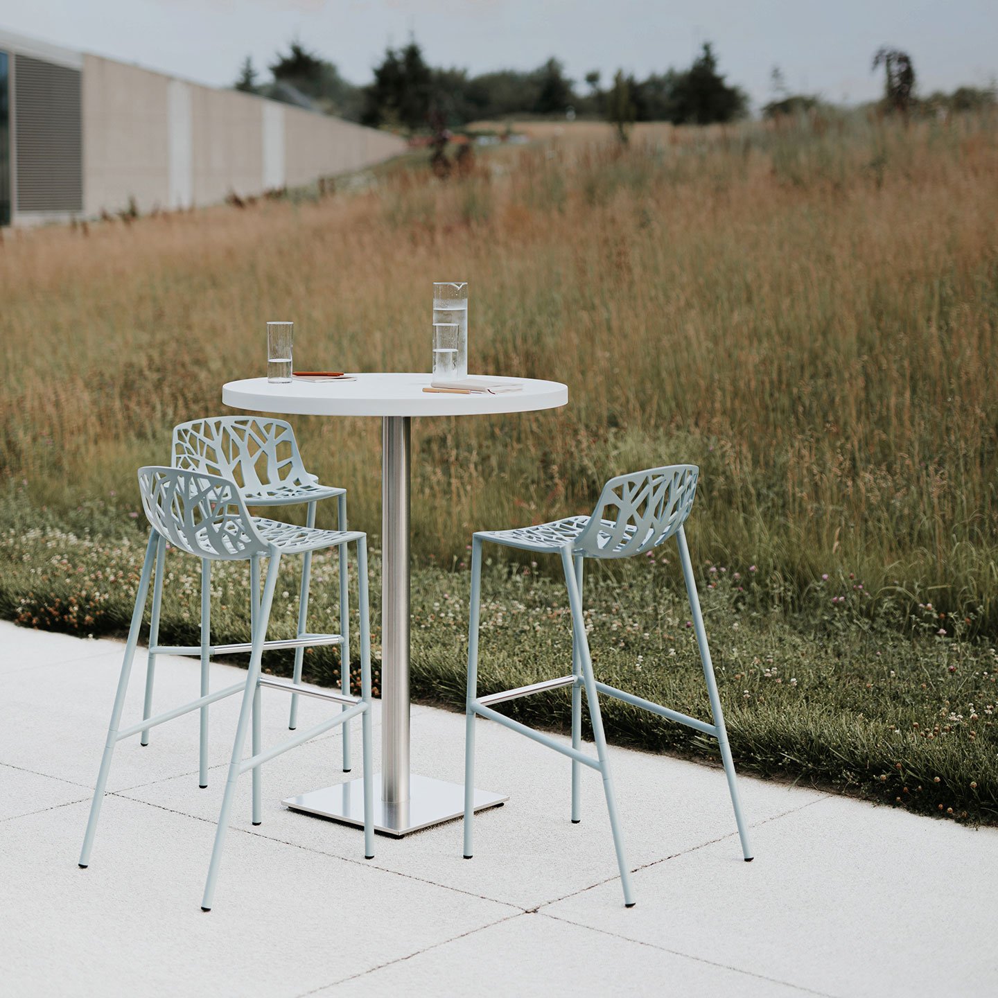 Haworth Forest stools in green in a casual outdoor space by the fields