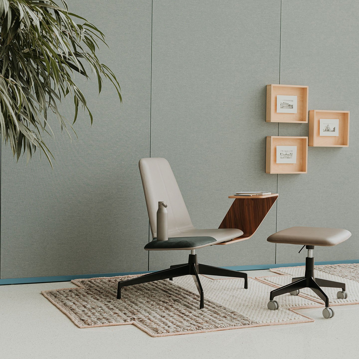 Haworth Harbor work lounge chair with attached study table in grey upholstery with a wheeled stool in a office space