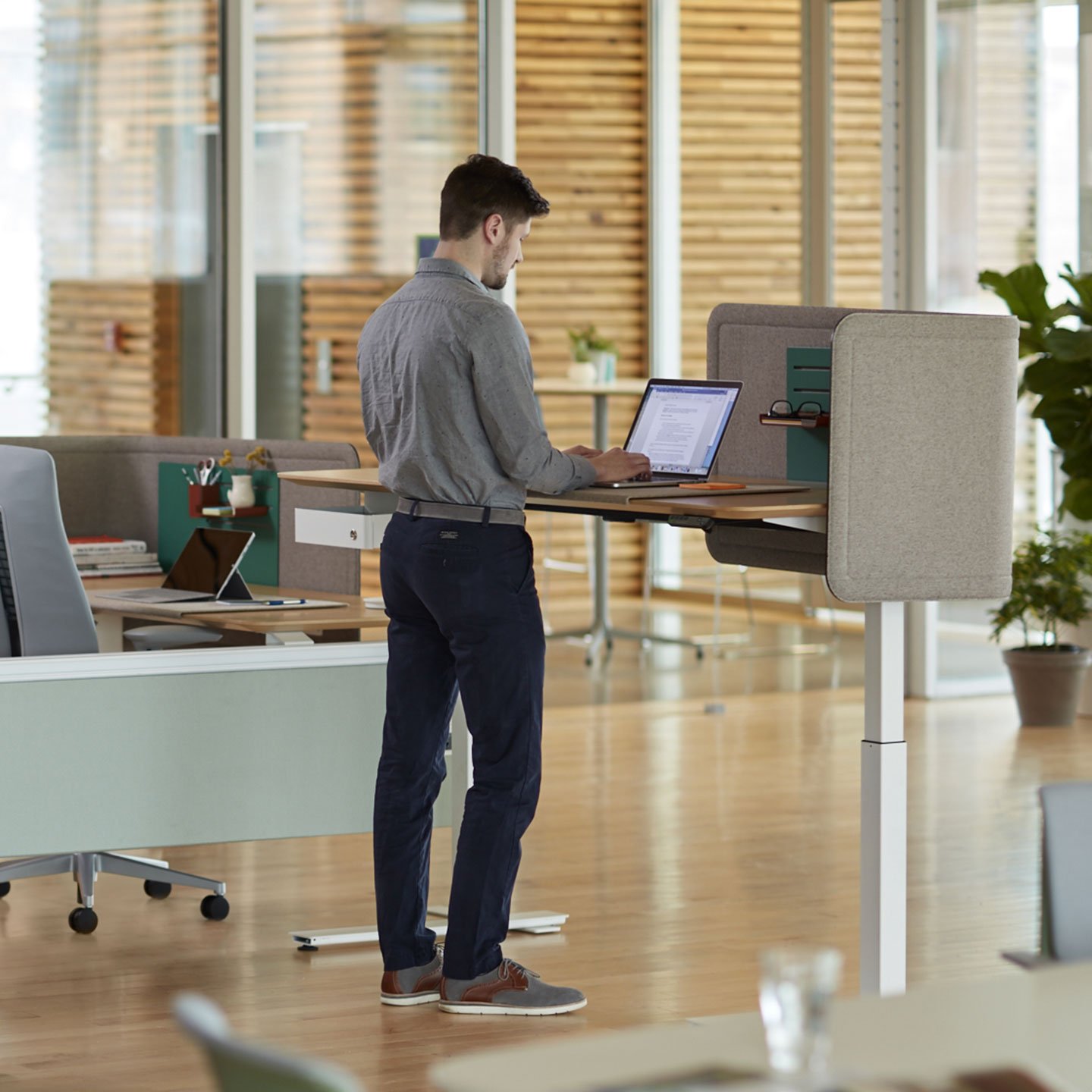 Haworth Curved Screens in gray at a standing desk