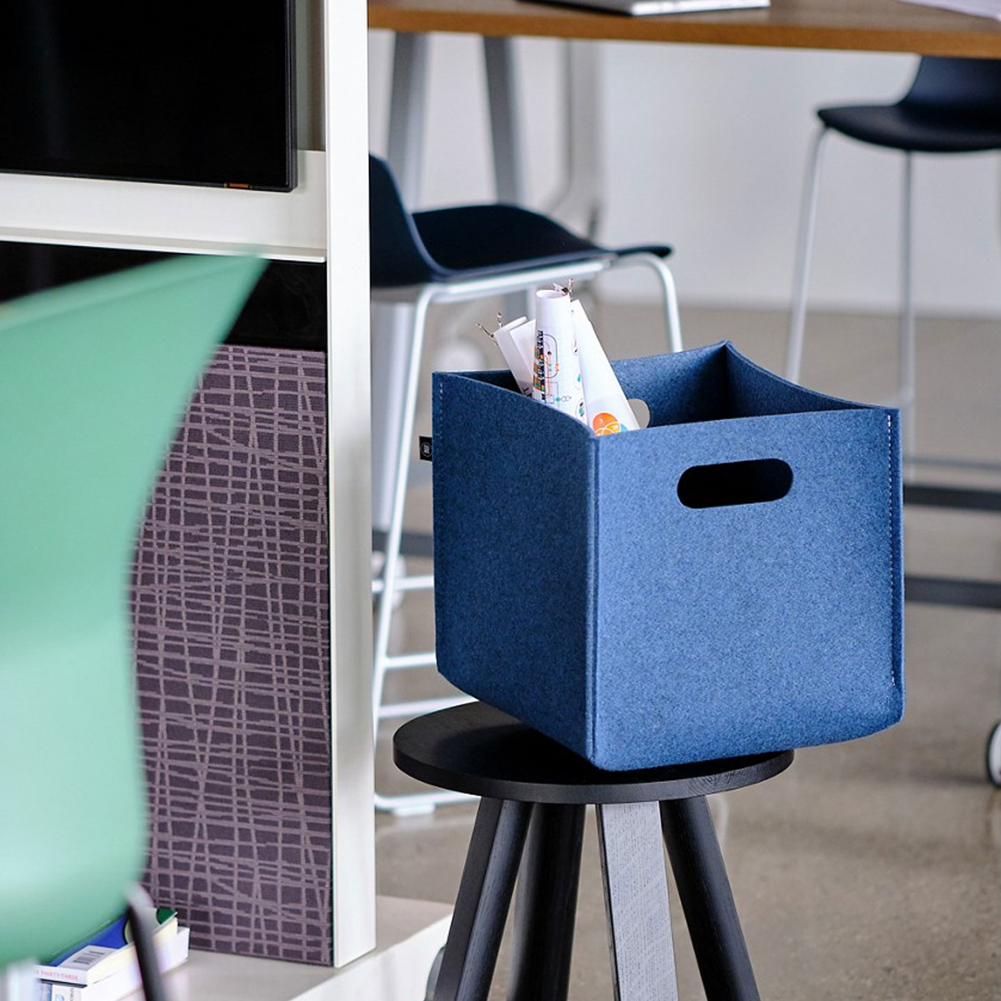 Buzzibox in blue on a black stool. 