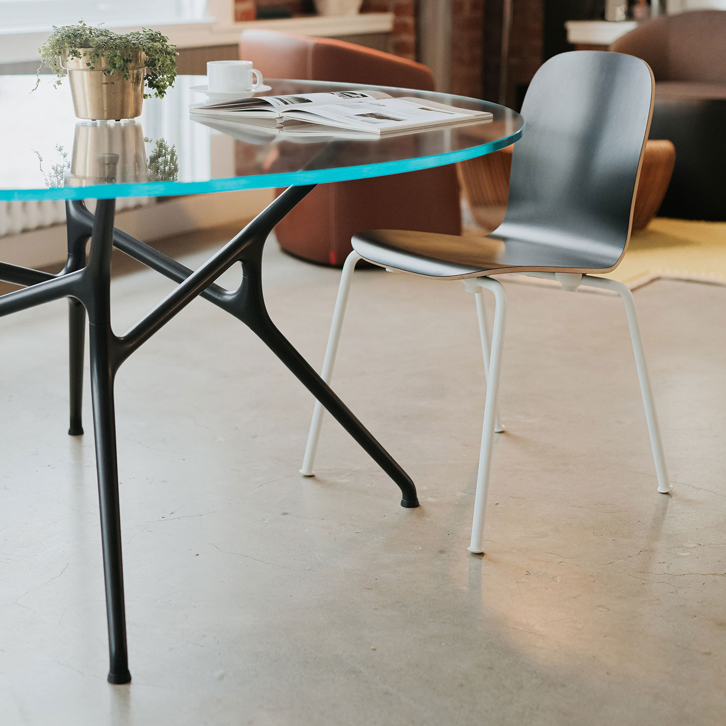 Haworth Branch Table with circular clear glass top used as a casual coffee table 