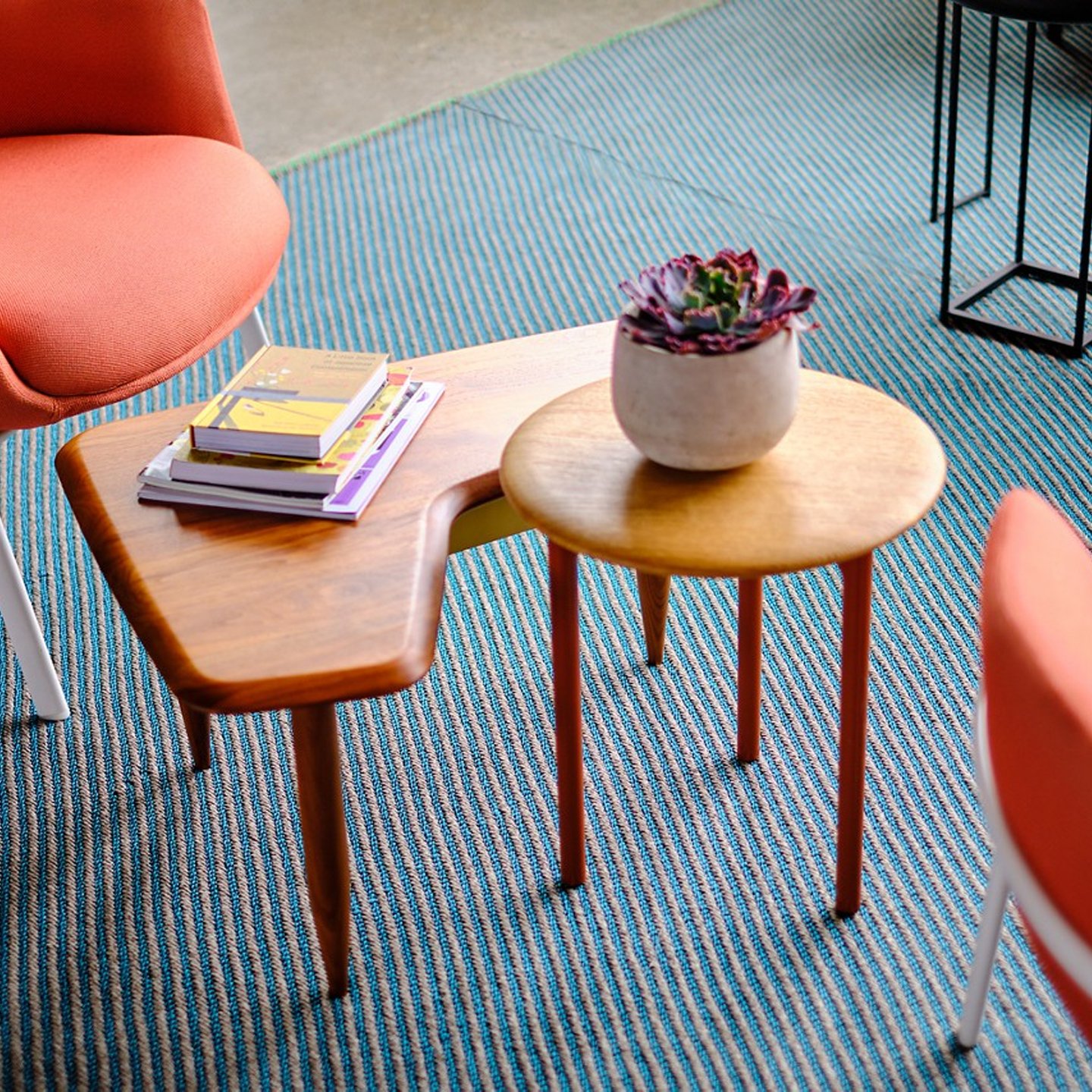 Haworth BuzziNordic Table walnut wood centered in conversation area with books on top