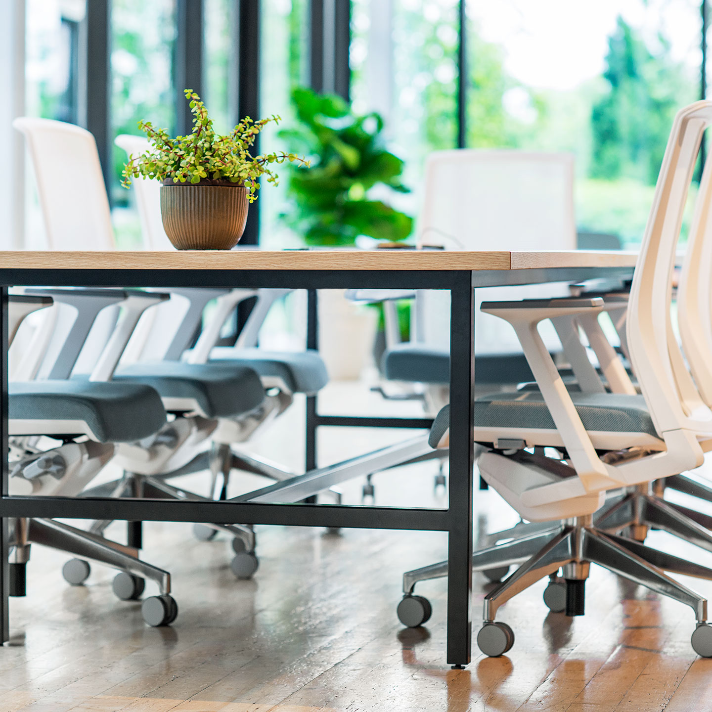 Haworth Cultivate table with 4 black legs and vaneer top in a meeting room with windows