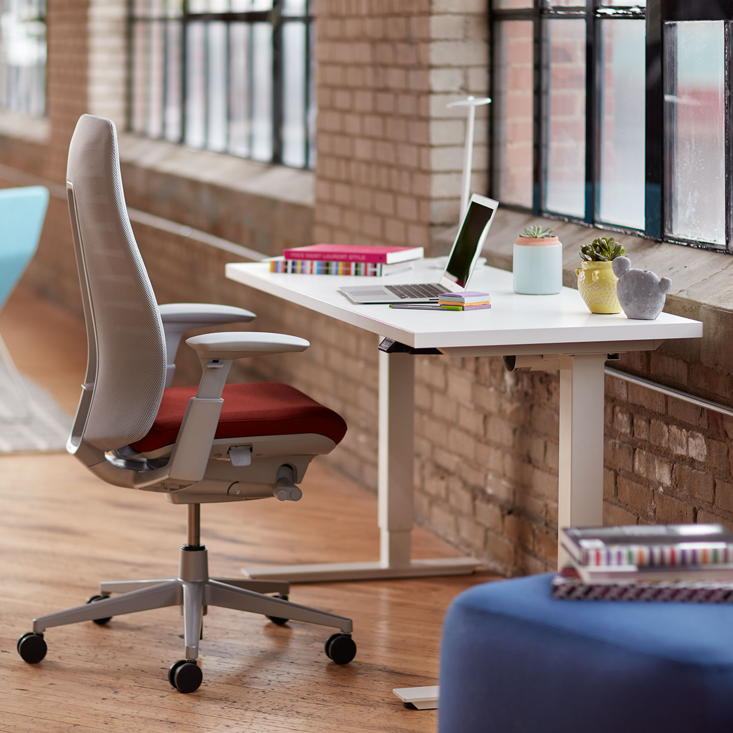 Haworth Height Adjustable Table being used as a small desk with Fern Seating in a open office space with windows