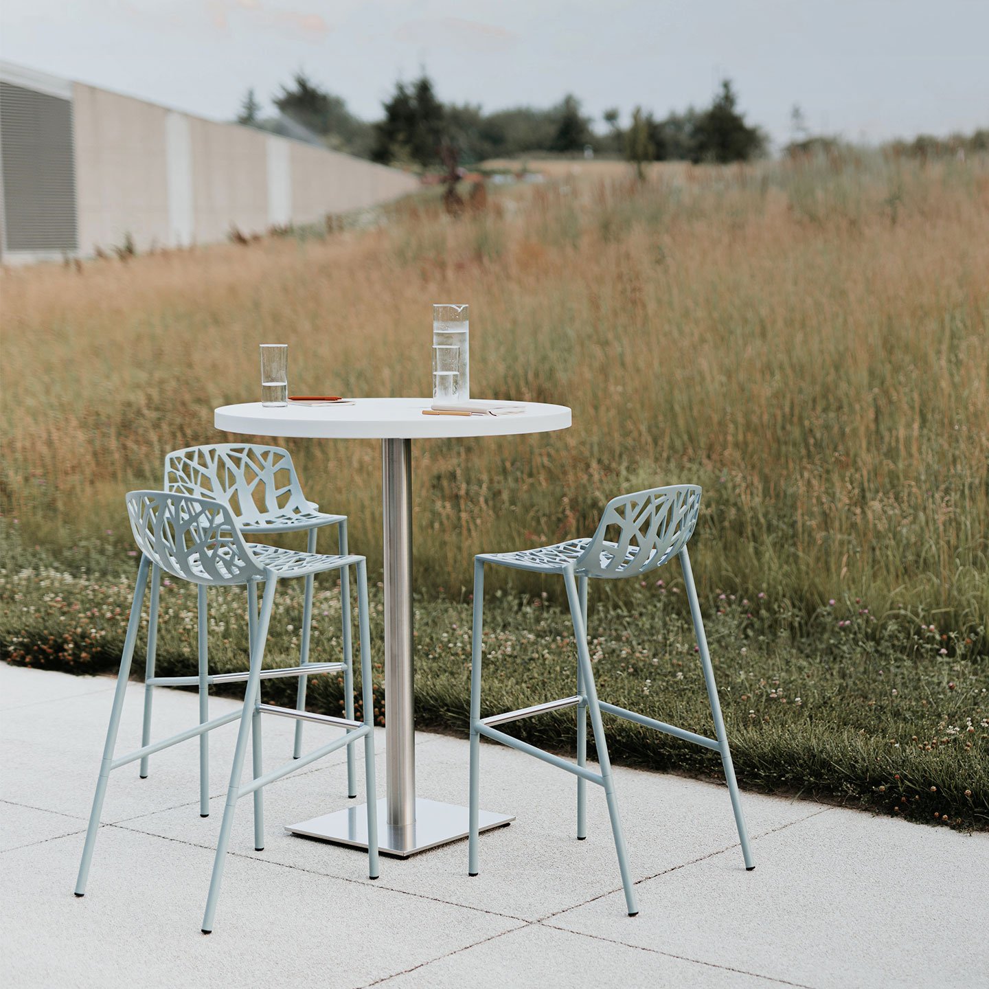 Haworth Janus Cafe Table in white laminate with circular top in outdoor patio area with 3 high chairs