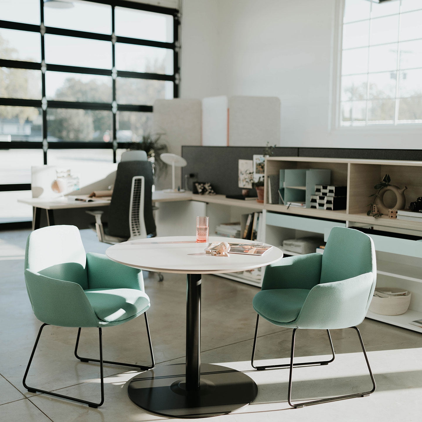 Haworth Jive Small Office Table with circular top in a casual office seating with fern chairs