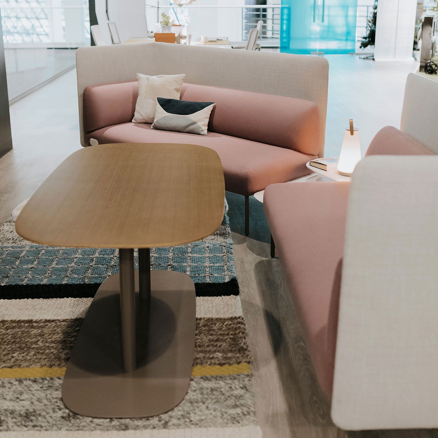 Haworth Pip Collaborative Table in white oak hardwood in a office collaboration setting near couches