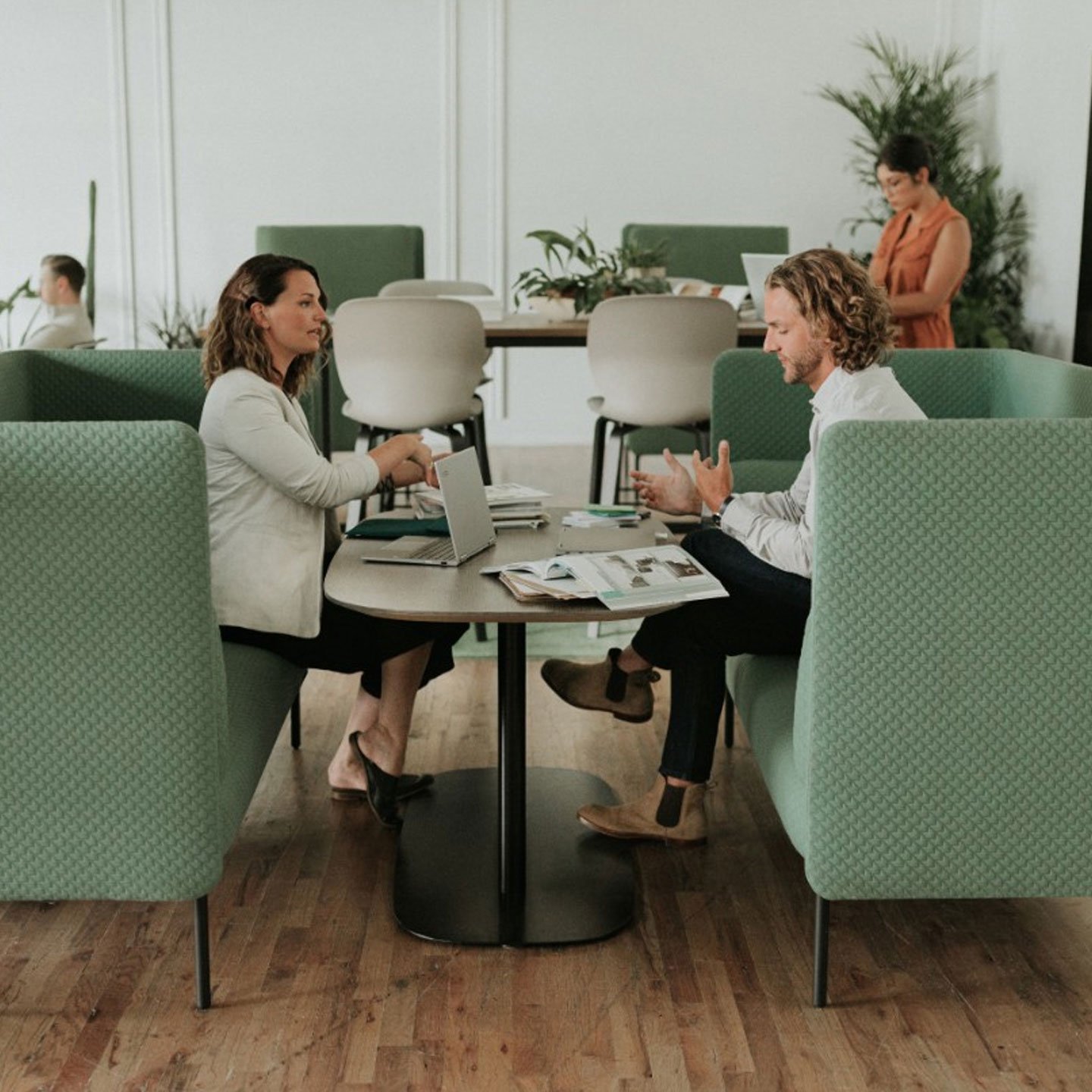 Haworth Pip Collaborative table in white in a open office seating with green couches having a meeting being done on them