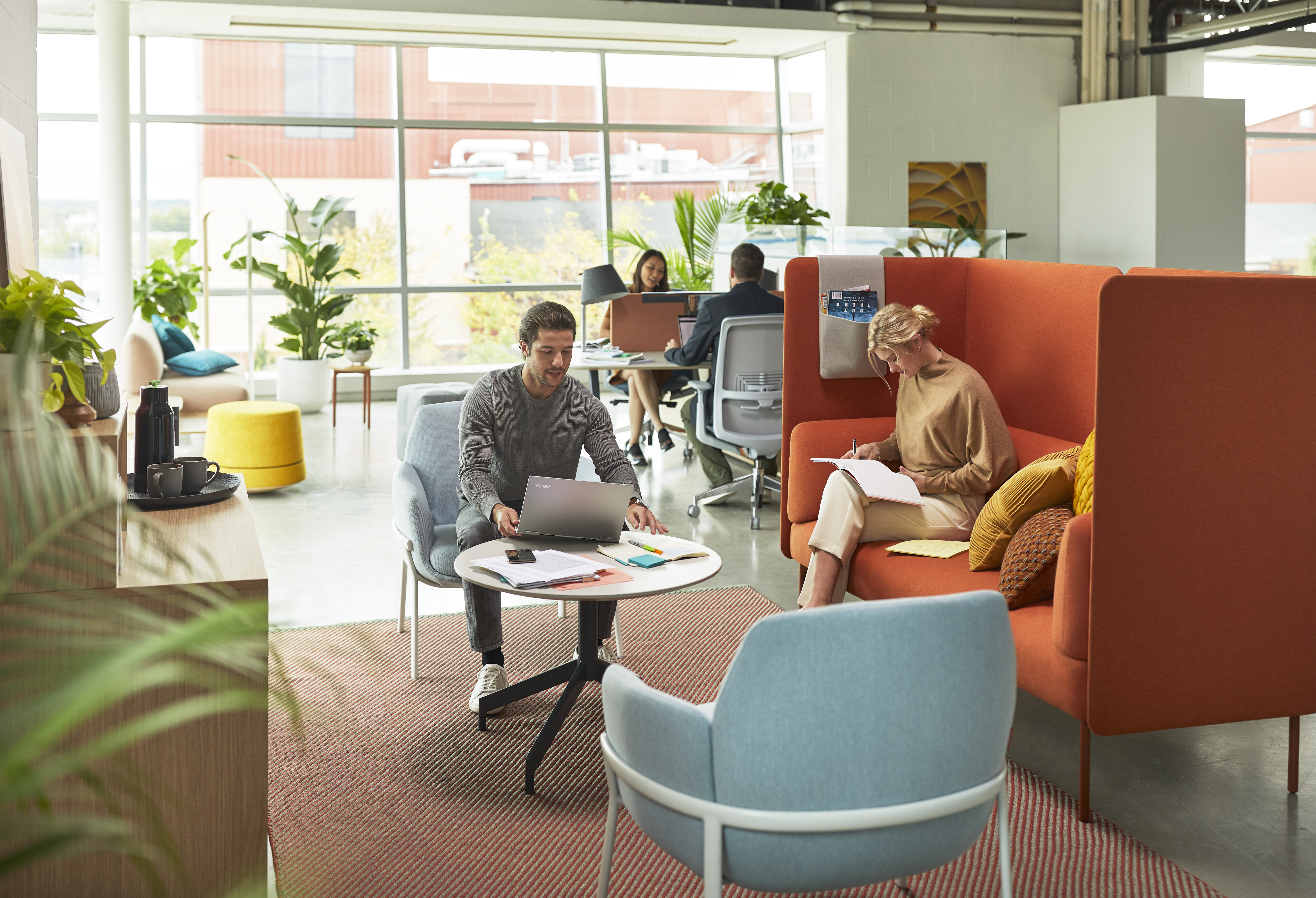 Haworth Planes Collaborative Table in an open office setting with employees collaborating around it