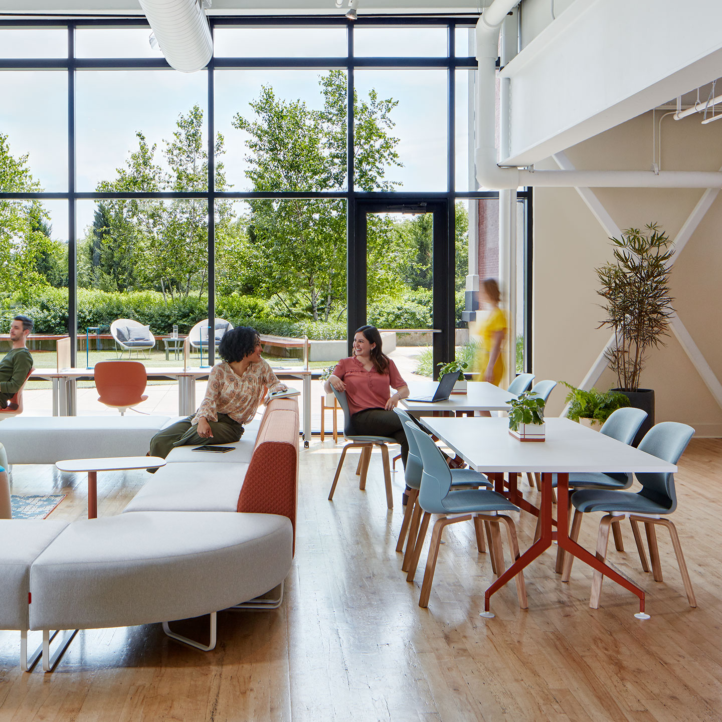 Haworth Planes Collaborative table in a office open work area with multiple couches and employees