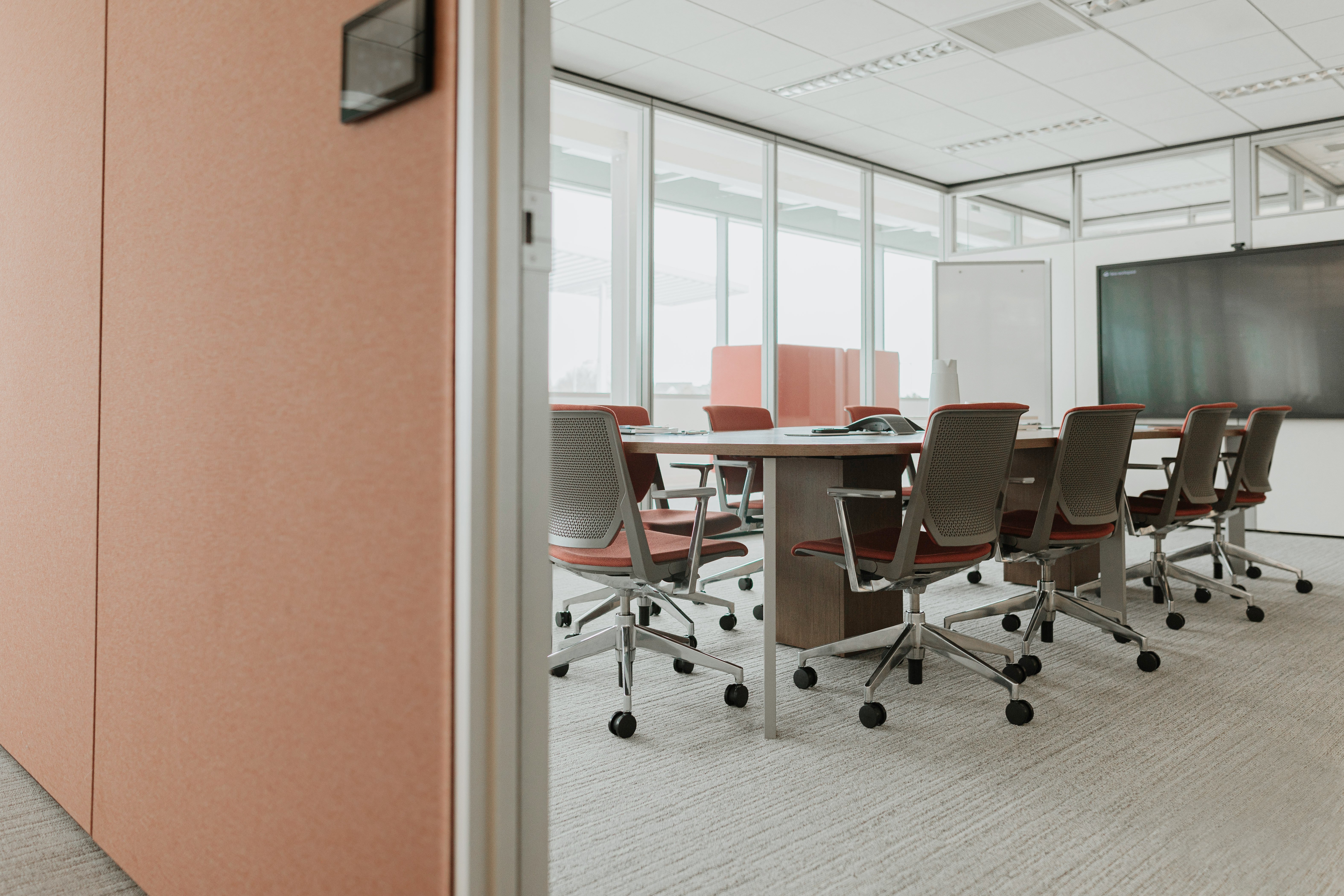 Haworth Planes Conference Table in a office meeting room that is closed off with white boards and chairs