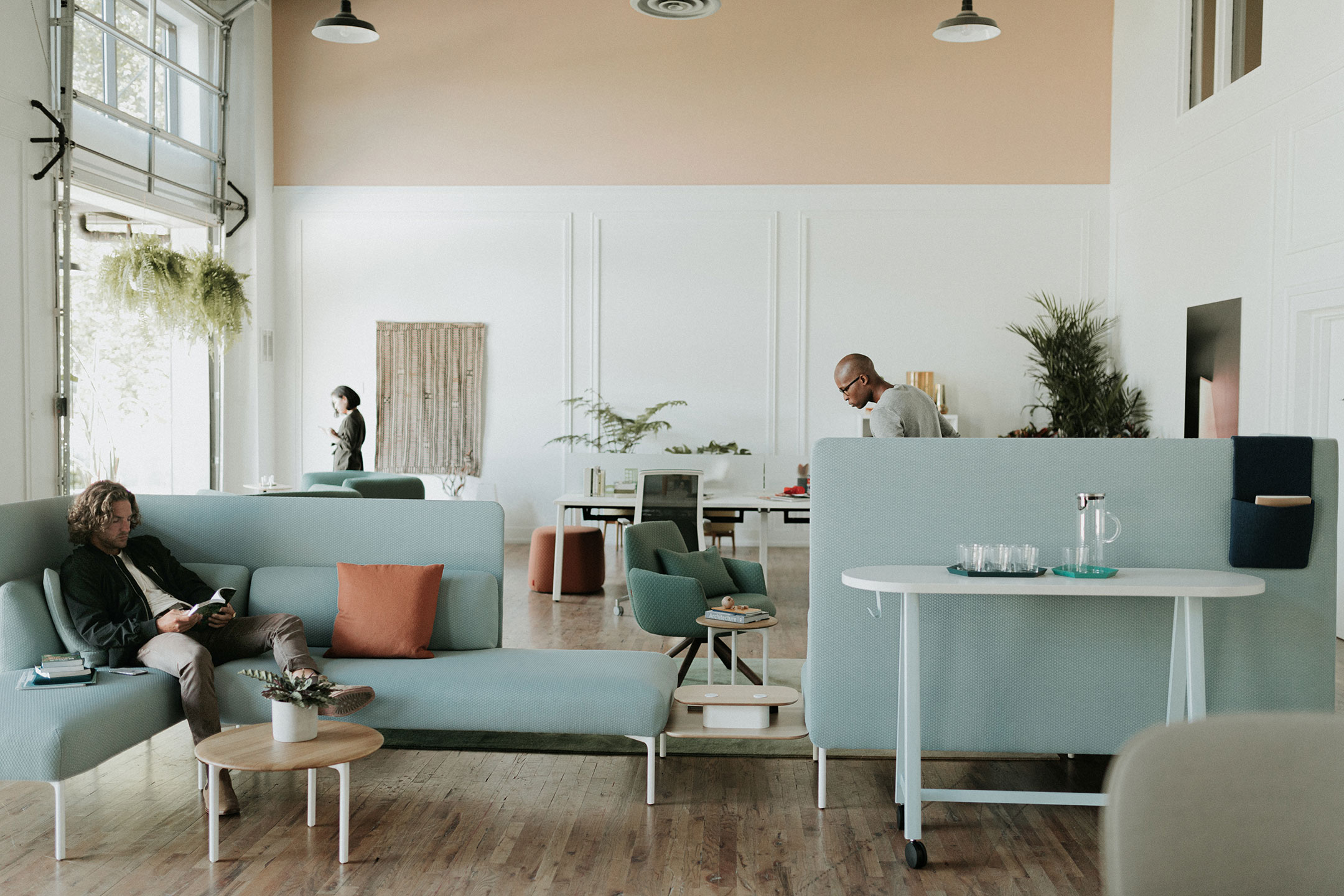 Haworth PopUp Table in a open office casual area used as a side table with employees working 