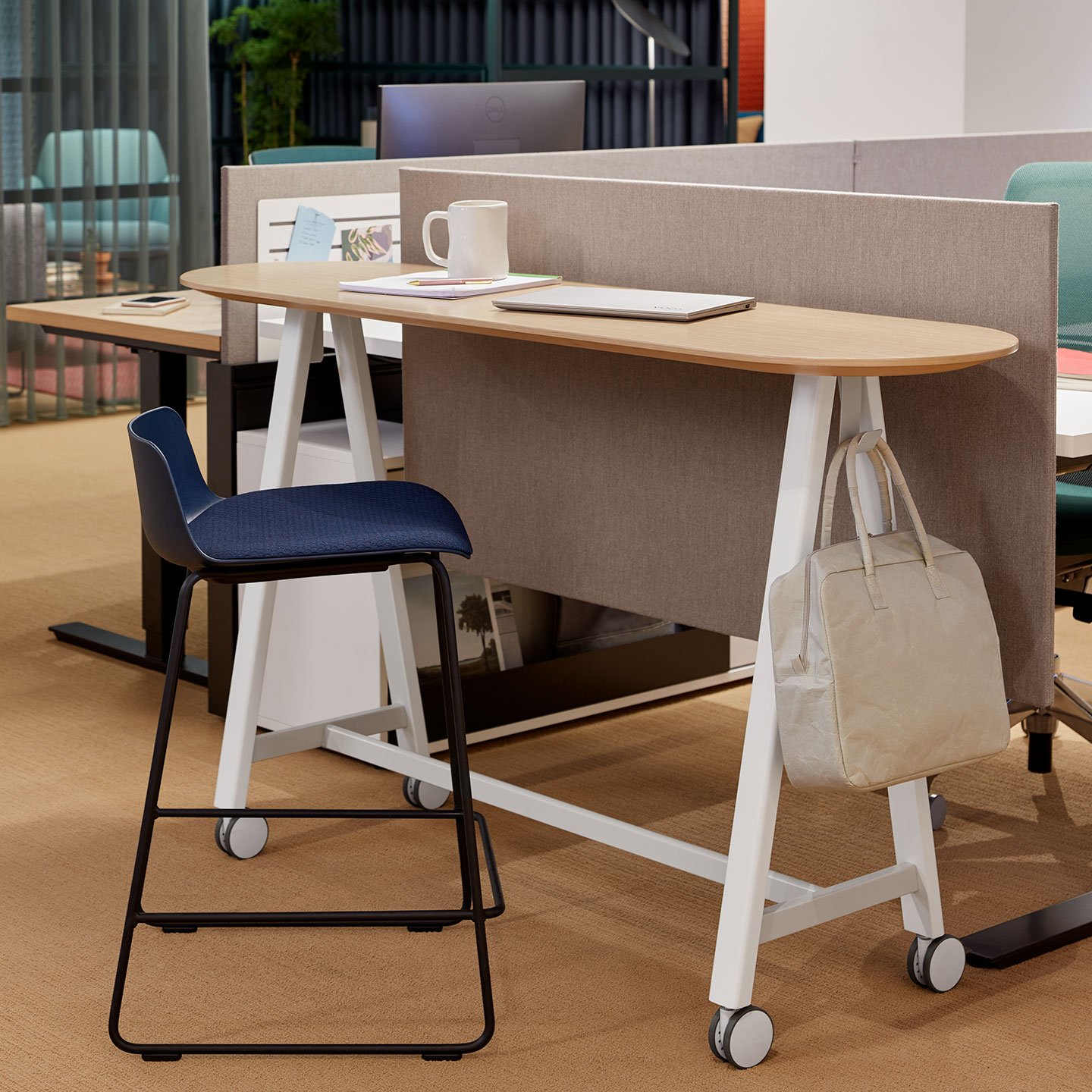 Haworth PopUp Table in a open office space with a laptop and mug on the table