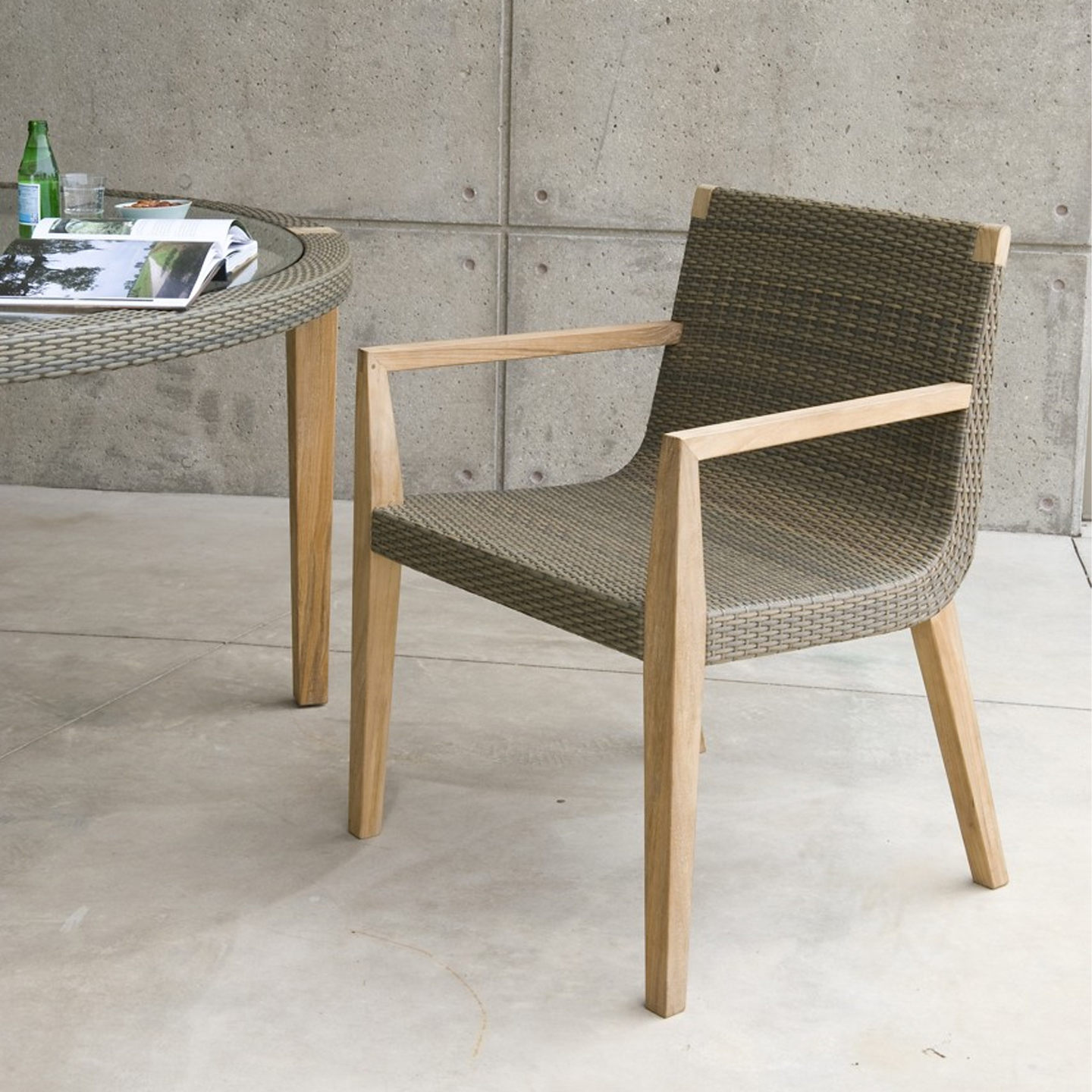 Haworth Quinta table with 4 wood legs and janusfiber trip with glass center next to Haworth Quinta chair with weaved seating