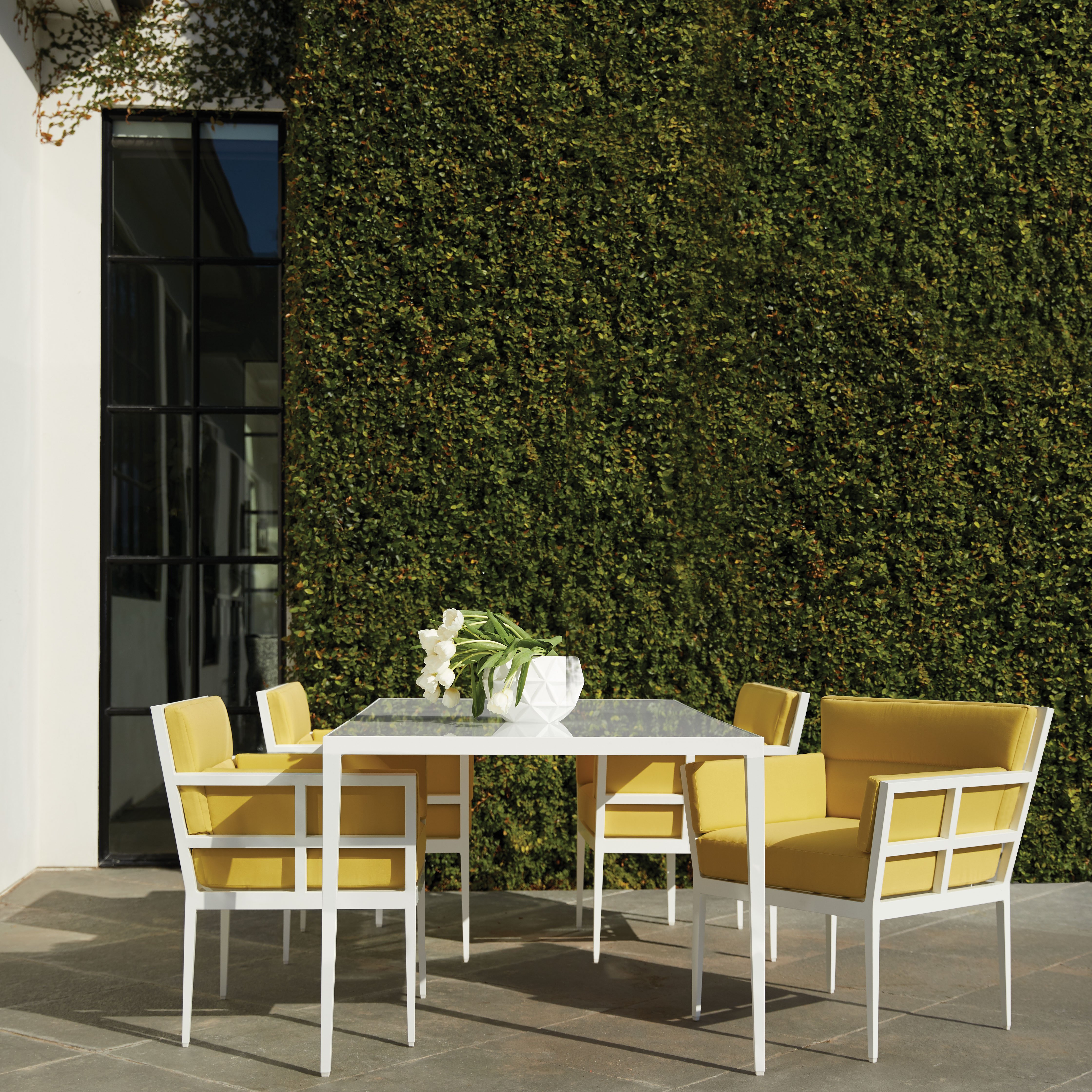 Haworth Slant table with white top in an outdoor patio area with a flower centerpiece 