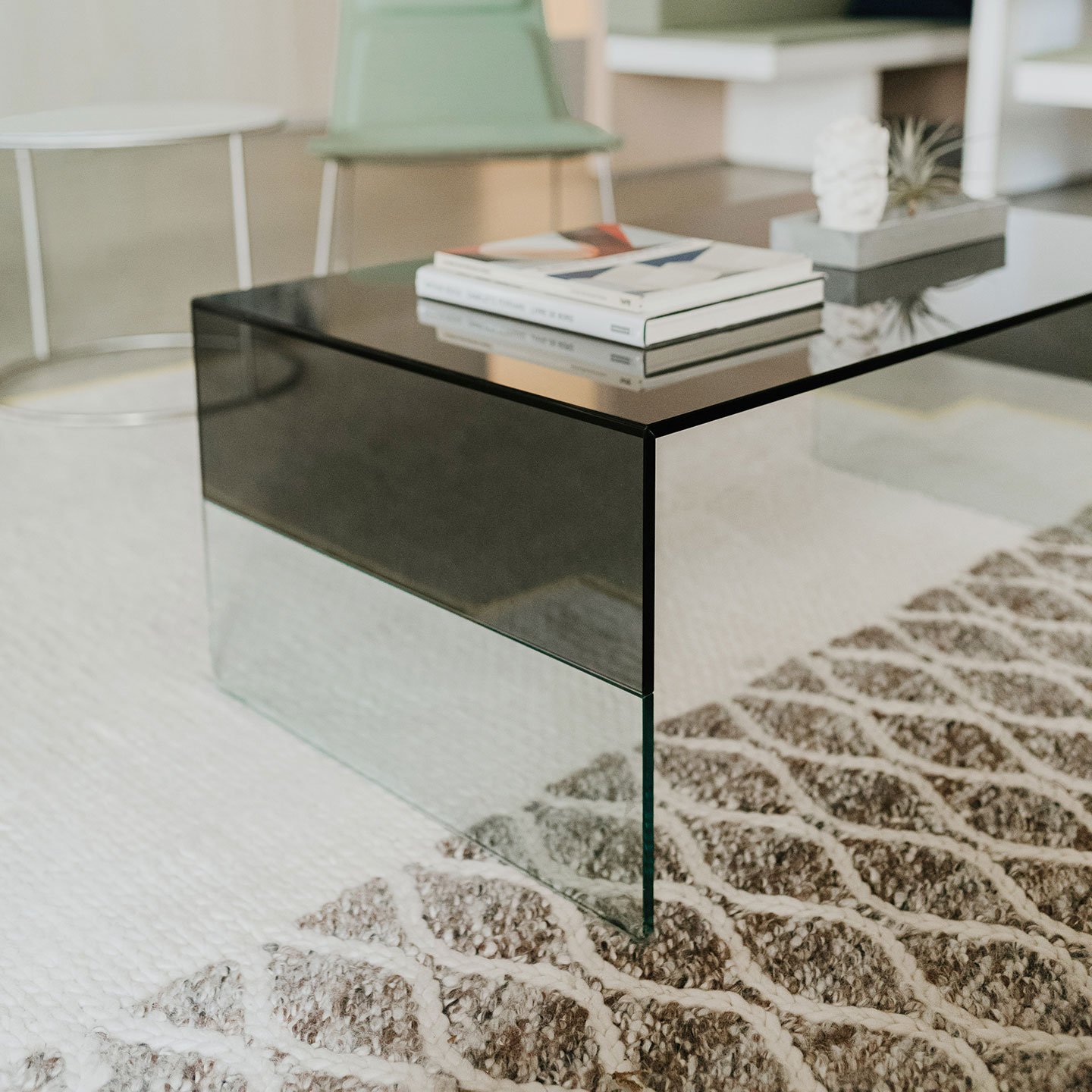 Haworth Smoke Table with square shape and smoked glass in a office lounge space being used as a book table