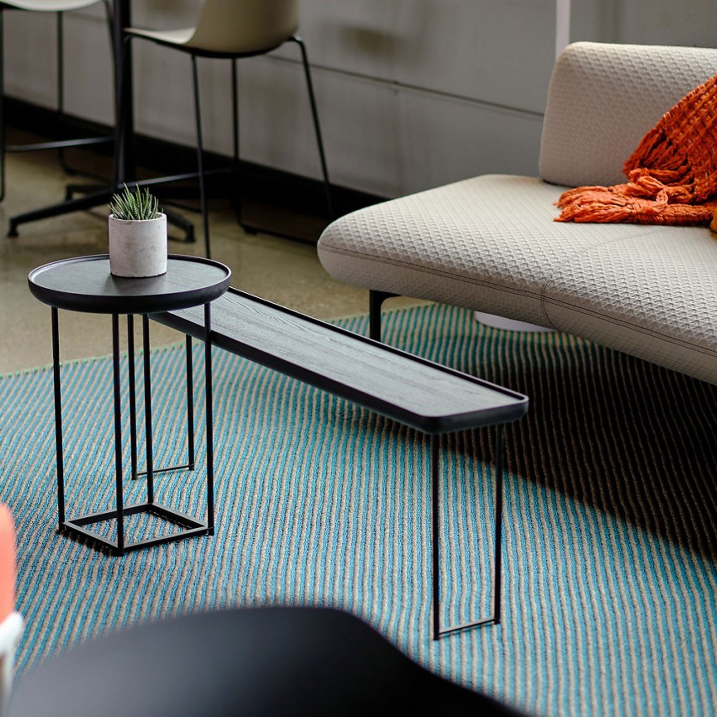 Haworth Torei Table in black stained ash in office lounge area with blue rug and couch