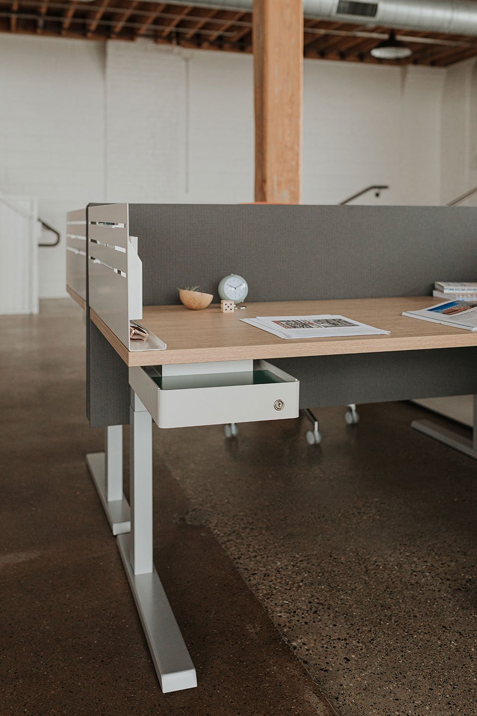 Haworth Upside Height Adjustable Table in an office setting with paper and a book on the table
