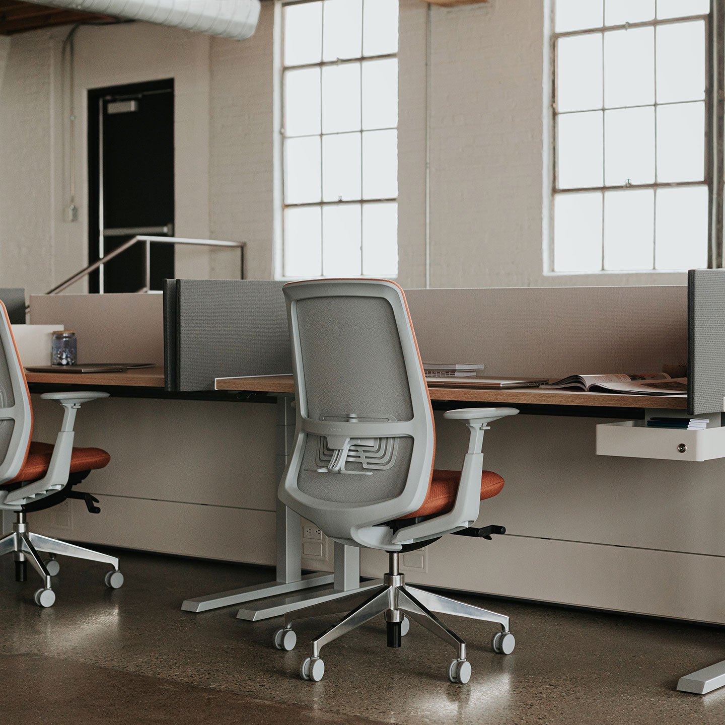 Haworth Upside Height Adjustable Table used as desks in office space with partially closed walls