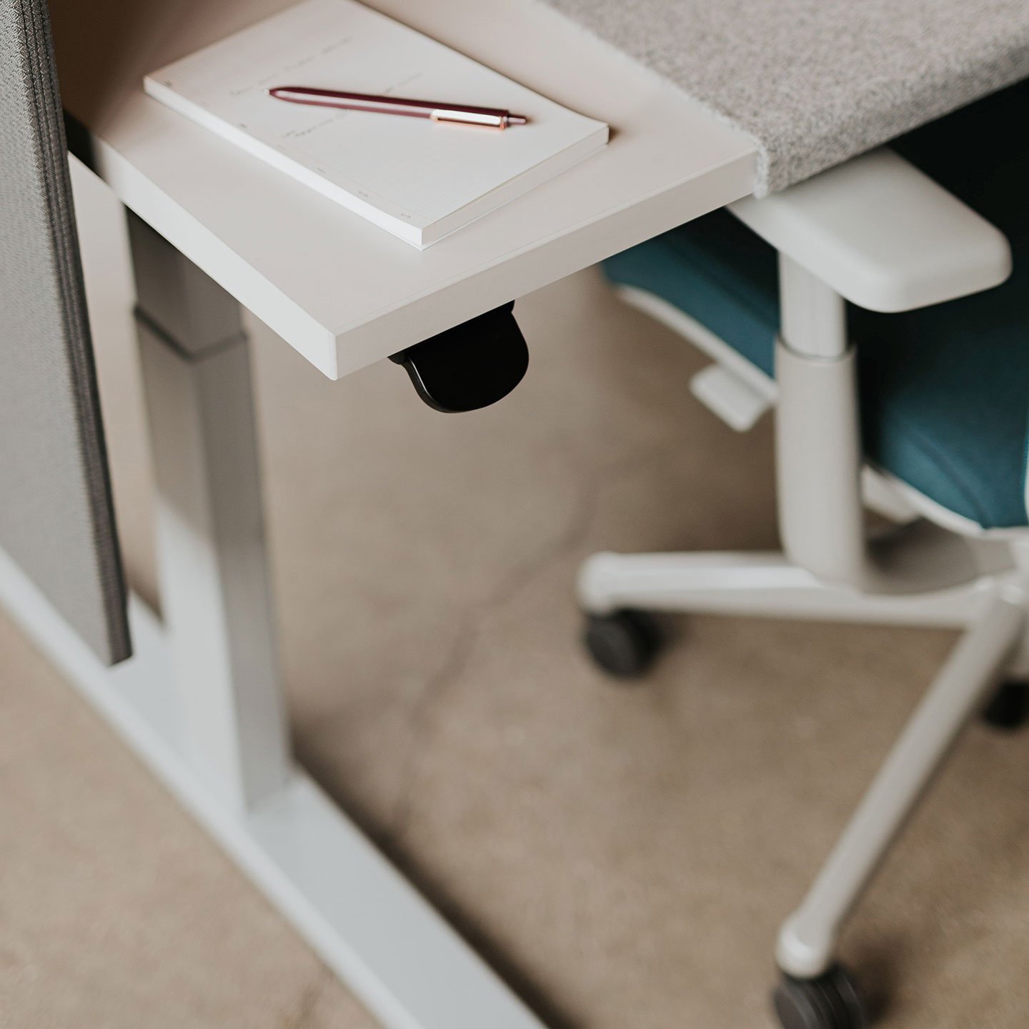 Haworth Upside Height Adjustable Table with pen and paper on it with haworth desk chair