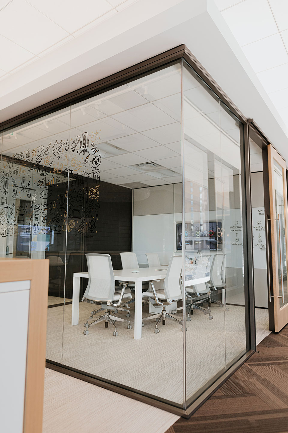 Haworth Enclose Frameless Glass Wall for closed meeting room with white wall and white chairs with white board on the wall in office 