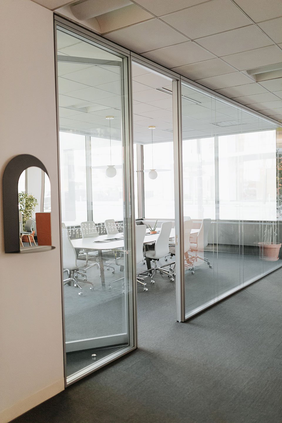 Haworth Enclose Frameless Glass Wall for private meeting room with white desk and white chairs