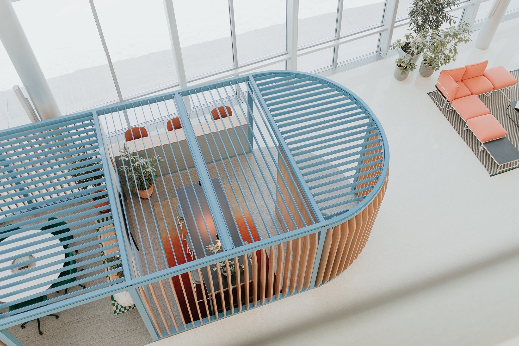 Haworth Pergola Workspace with blue beams and veneer slits with black table inside in open office space