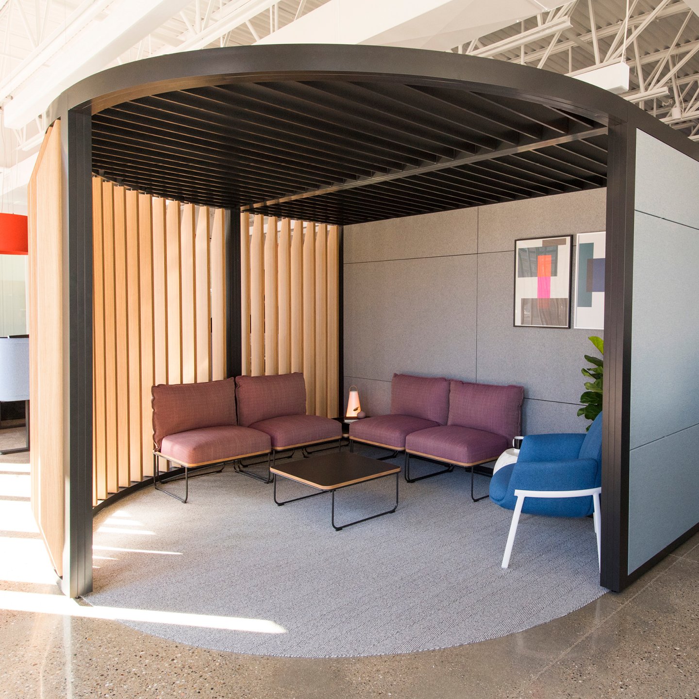 Haworth Pergola Workspace in black trim and veneer slits and grey wall with couches and coffee table in open office