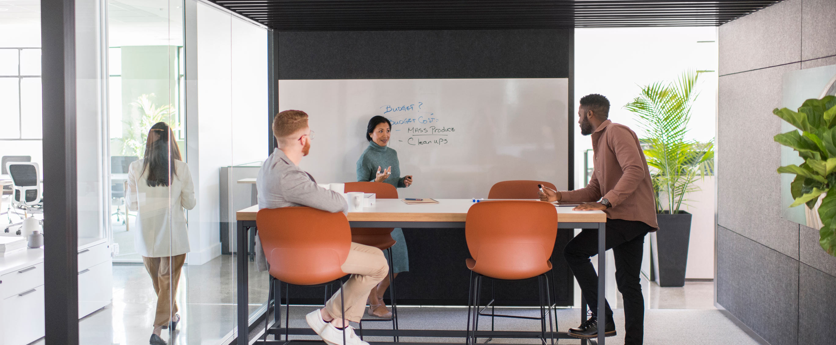 Haworth How to leverage space for high performing teams Spark team in private work space with tall table and orange chairs and white board