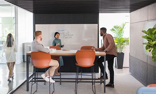 Haworth How to leverage space for high performing teams Spark team in private work space with tall table and orange chairs and white board